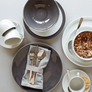 Grey and white tableware are set for breakfast.