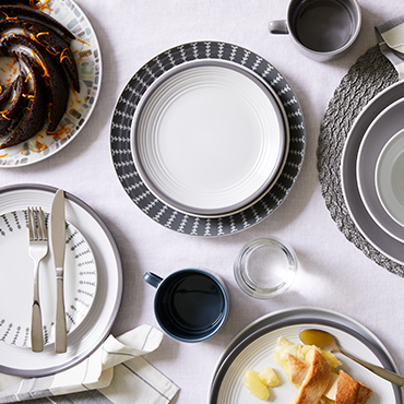 A collection of layered grey and white coloured dinner sets.
