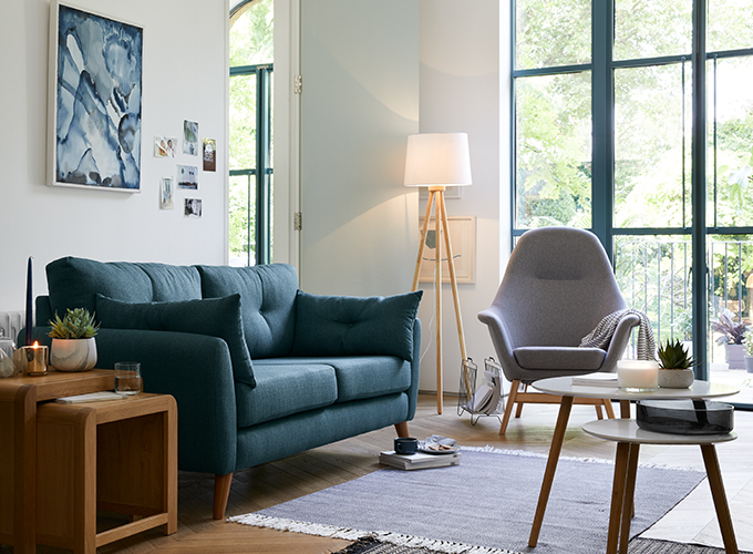 A grey and blue Scandi themed living room, with statement blue sofa.