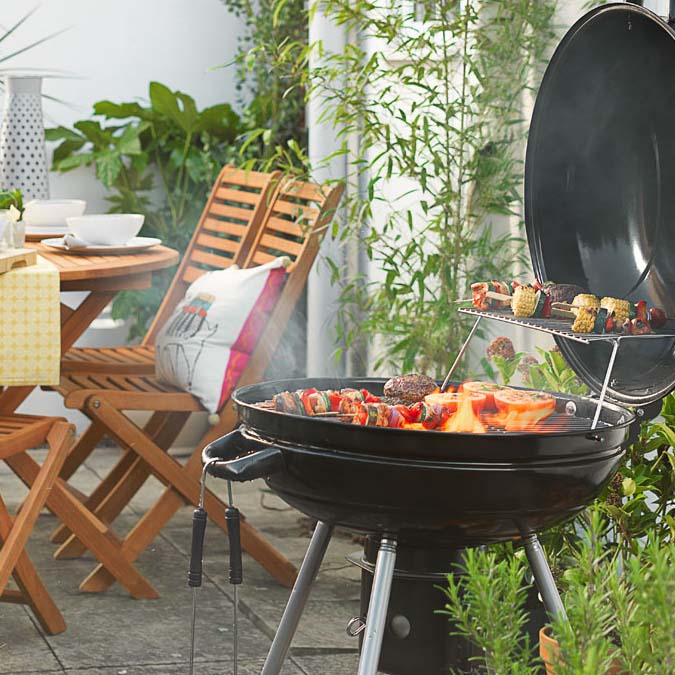 Best Bbq Argos Black Charcoal Bbq With Wooden Garden Table And Chairs In Background
