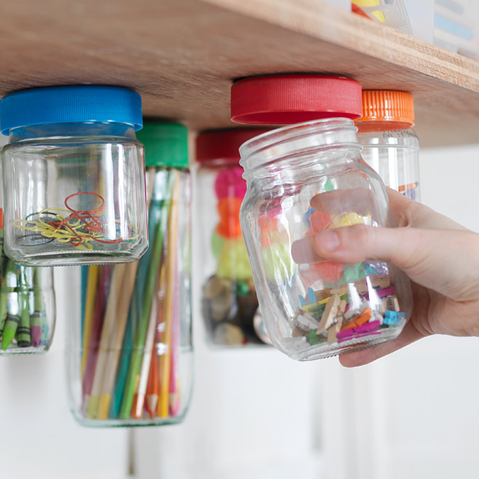 Image of plastic storage jars attached to the underside of the shelf.