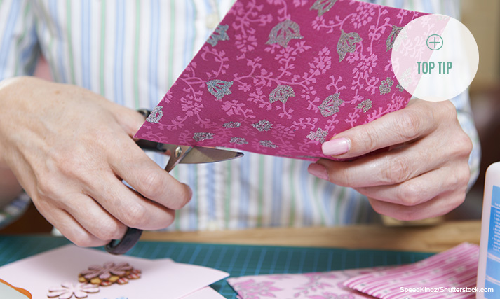 Woman cutting patterned card.