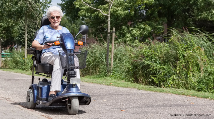 Woman driving three-wheel mobility scooter.