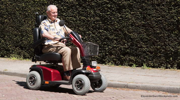 Man driving four-wheel mobility scooter.