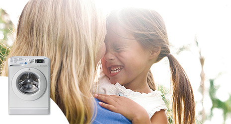 A woman and child with with a cut out image of an Indesit washing machine.