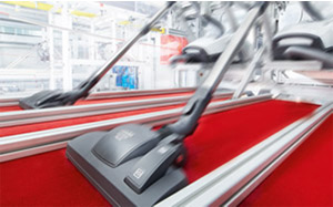 Lifestyle image of 2 Miele vacuum cleaner heads running down a red carpeted floor set out in lanes.
