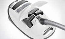 Image of an ariel view of a white Miele vacuum cleaner showing the range of integrated tools.