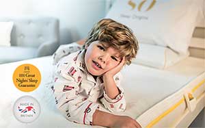 Image of a child lying on a Sleep Origins mattress propping his head up with his hand.