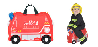 Image of a child riding a suitcase themed like a fire engine.
