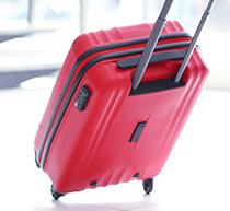 Image of a red hard sided suitcase with the handle extended.