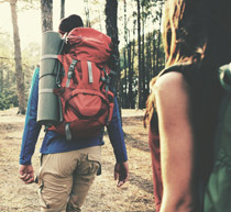 Image of two people hiking, carrying large holdalls.