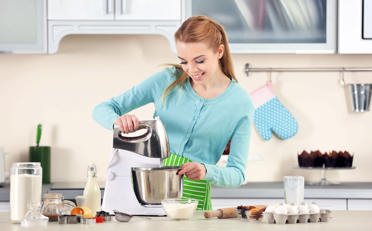 Woman using a food processor to make a dough.