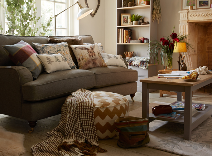 Country style living room with grey fabric sofa, wood living room furniture and rustic styling.