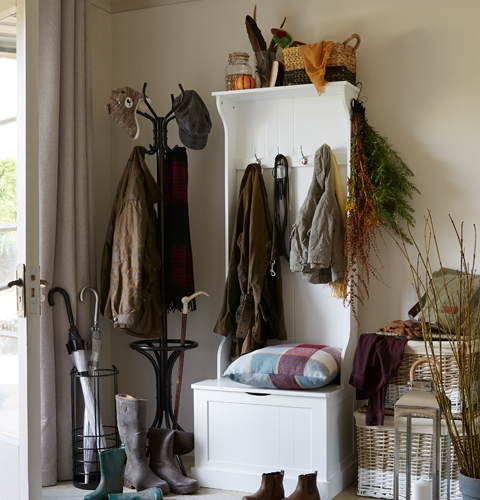 Entrance hallway with storage boxes, coat stands and lots of shoes and coats.