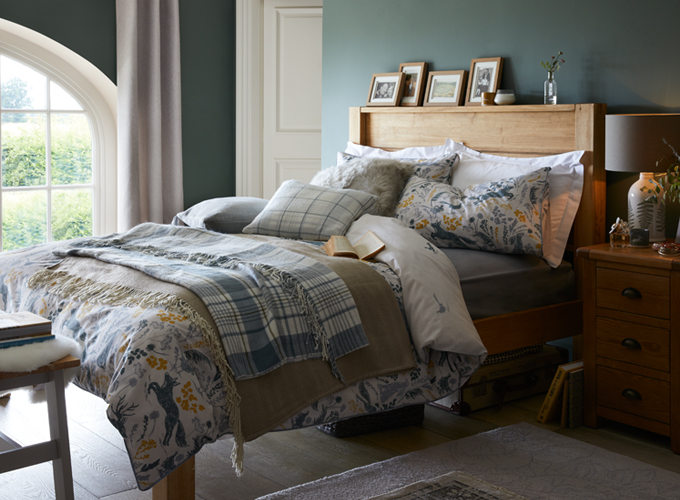 A country style bedoom with forest green wall and oak-finish bedroom furniture.
