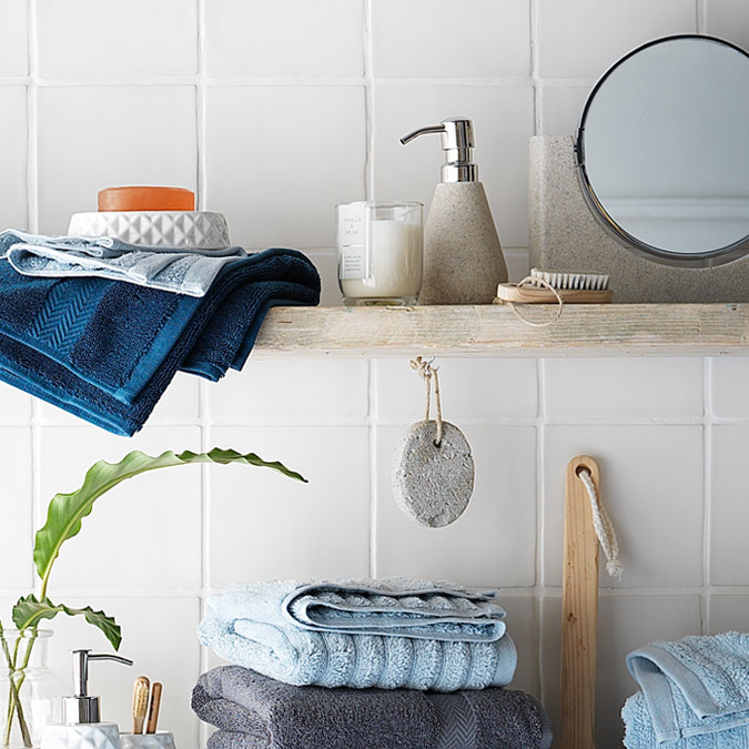 Bathroom accessories and towels folded on shelving.
