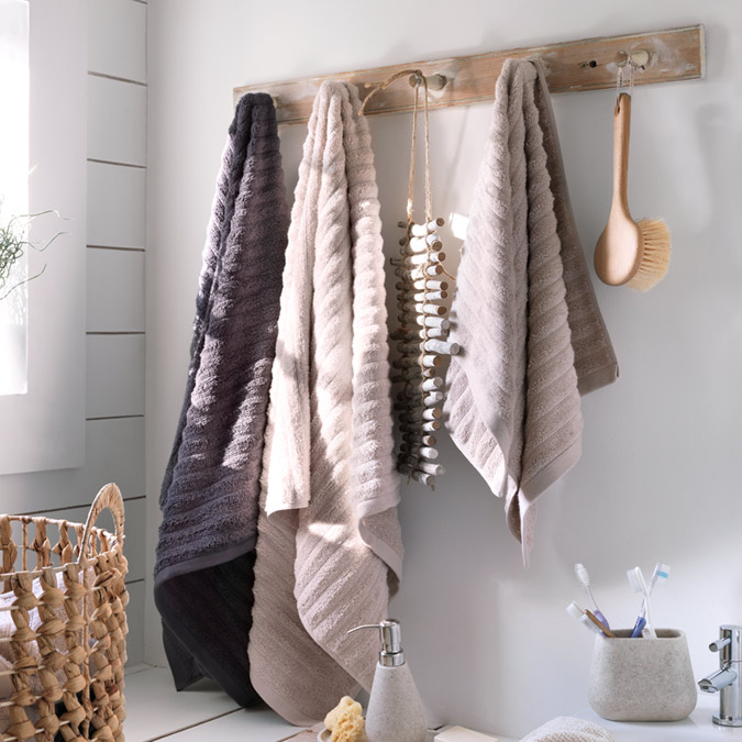 Bathroom towels hung up on wooden pegs.