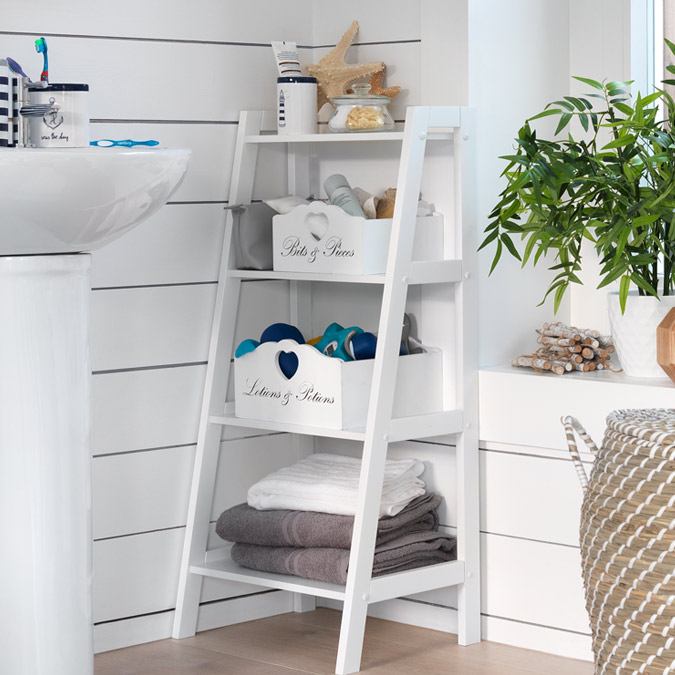 Corner of a bathroom with white sink and white ladder storage featuring bathroom storage boxes.
