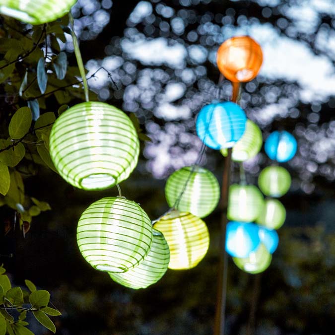 Colourful paper garland string lights hung on a tree.