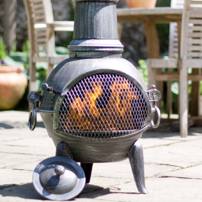 Steel chiminea on a stone patio.