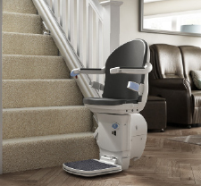 Age UK stairlift fixed at right hand size, bottom of flight of stairs.
