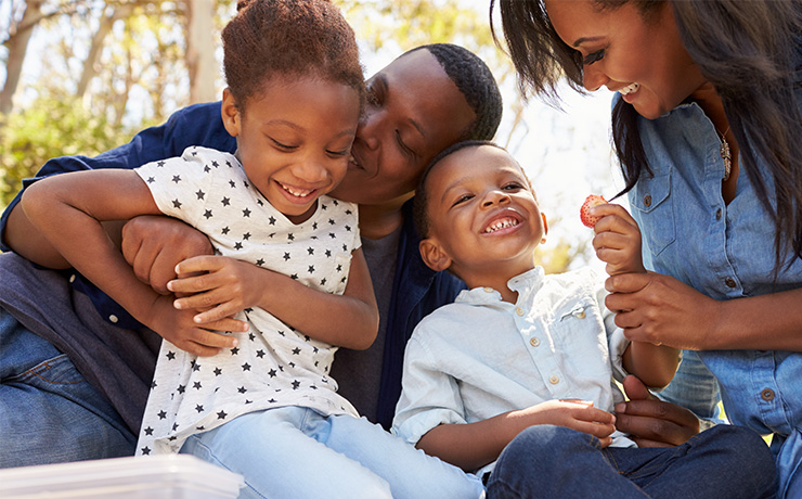 Image of a family having a picnic and playing games in the park