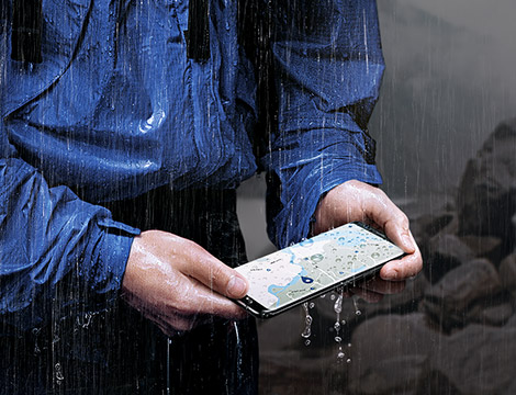 Image of a person ussing the Samsung Galaxy S8+ being used in the rain.