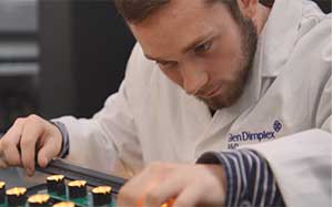 Image of a man testing a Dimplex appliance in a factory environment.