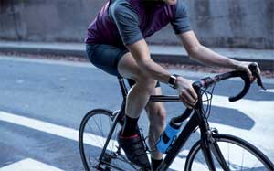 Image of a person on a racing bike on the road wearing a Fitbit Ionic.