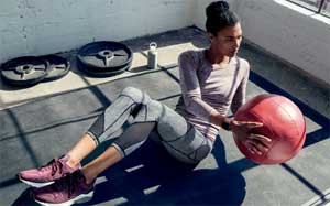 Image of a woman exercising with a ball in the gym.