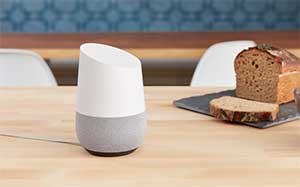 Image of a Google Home on a kitchen worktop with a loaf of bread next to it with 1 slice cut off.