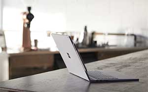 Rear view image of a Surface Book open on a table top at the back of a room