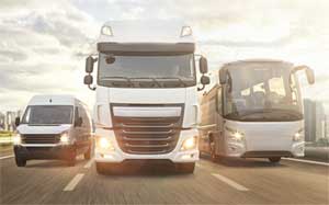 Image of a bus, lorry and a minibus driving towards the camera using all 3 lanes on a motorway.